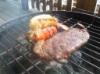 Jerk steak and a lobster tail on the grill